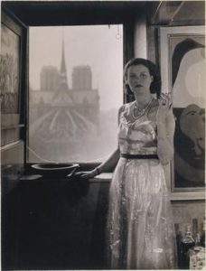 Peggy Guggenheim, c.1930, Paris, photograph Rogi André (Rozsa Klein). In the background, Notre Dame de Paris, and on the right, Joan Miró, Dutch Interior II (1928).
