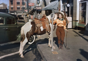 A cowgirl puts a nickel in an El Paso parking meter to hitch her pony, October 1939.
